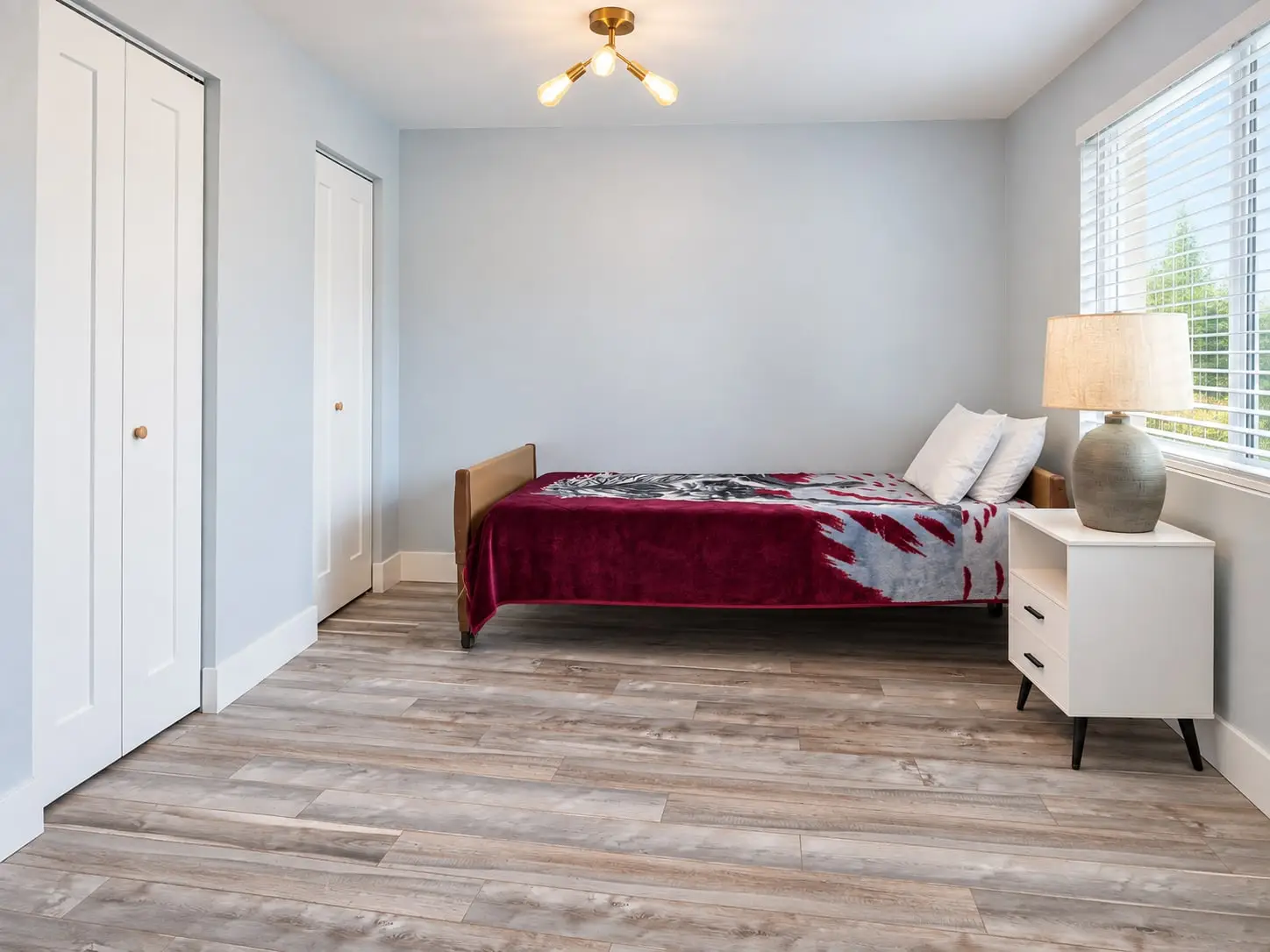 Bedroom seen from the doorway, with bed, nightstand and window