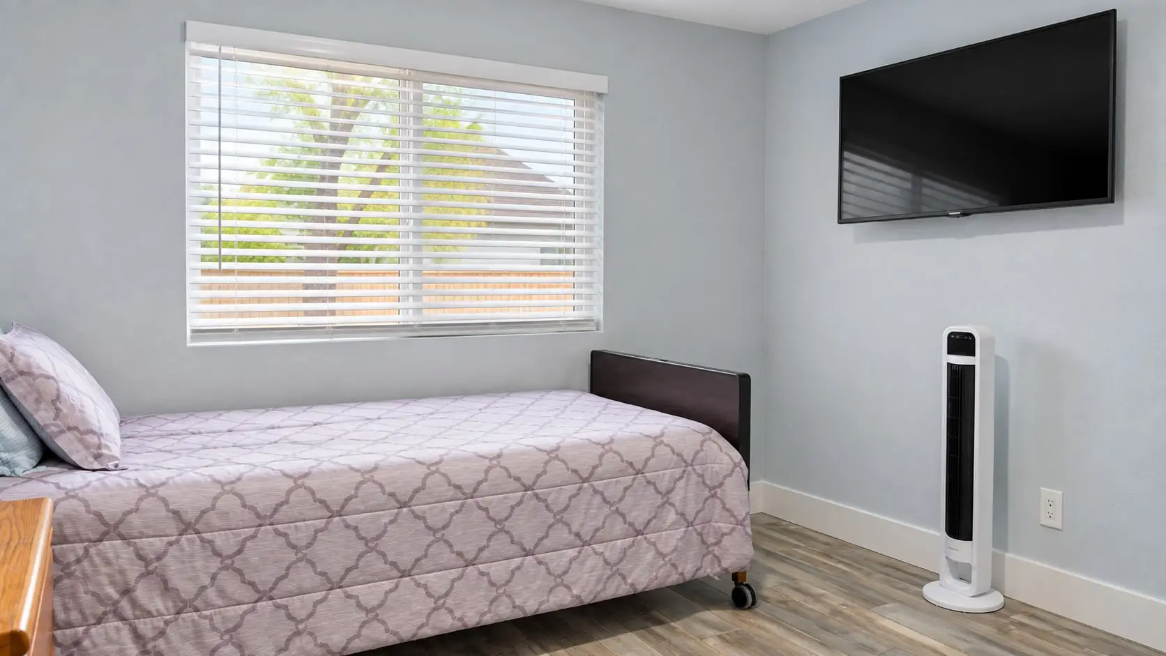 Bedroom with a single bed and a wall-mounted TV