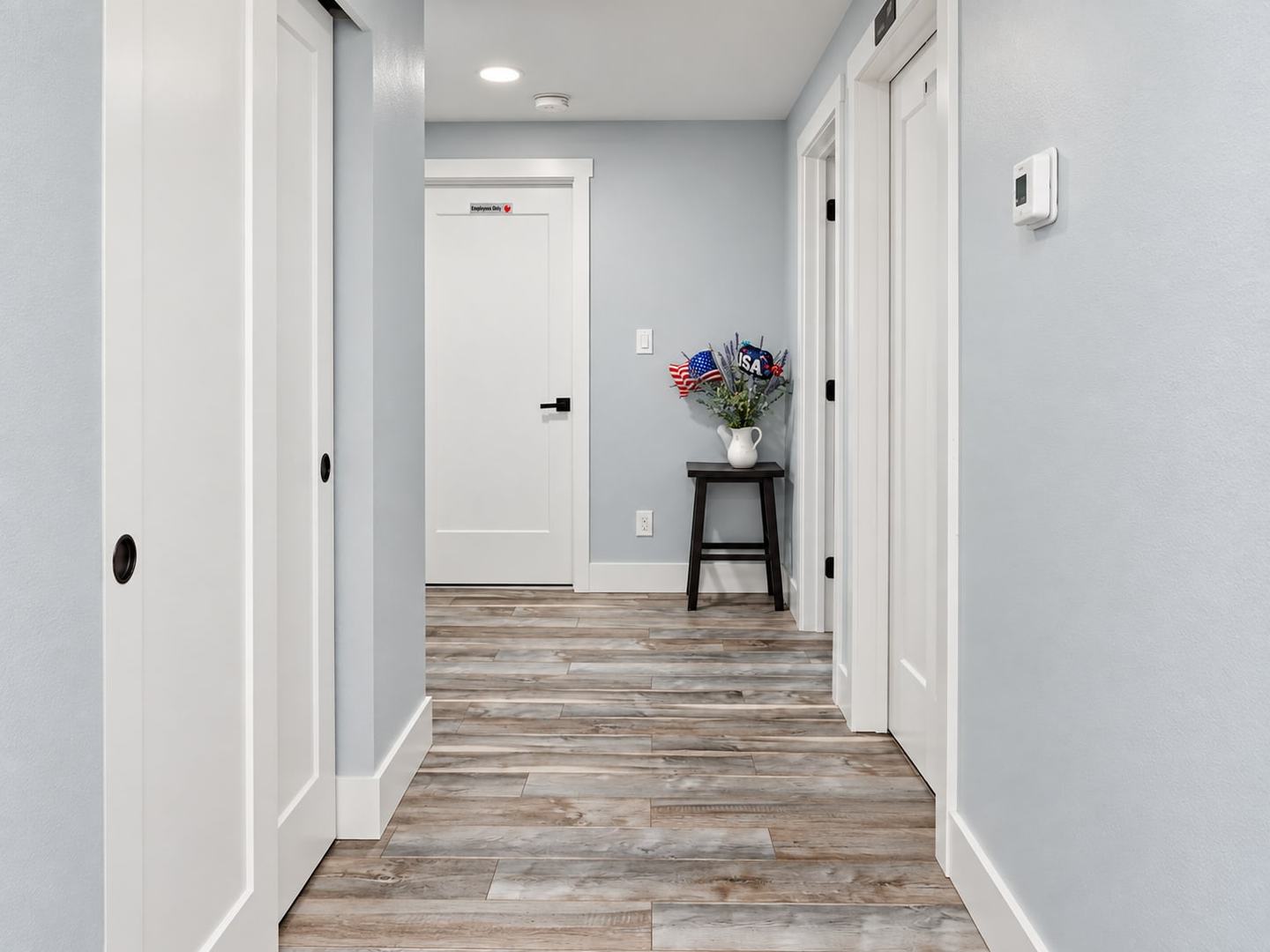 Hallway with wood-look flooring leading to the bedrooms