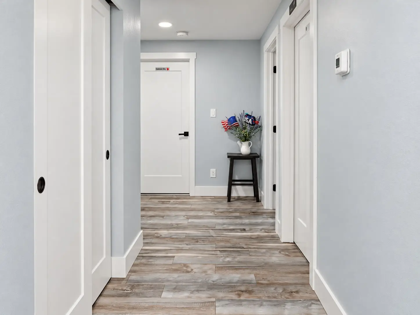 Hallway with wood-look flooring leading to the bedrooms